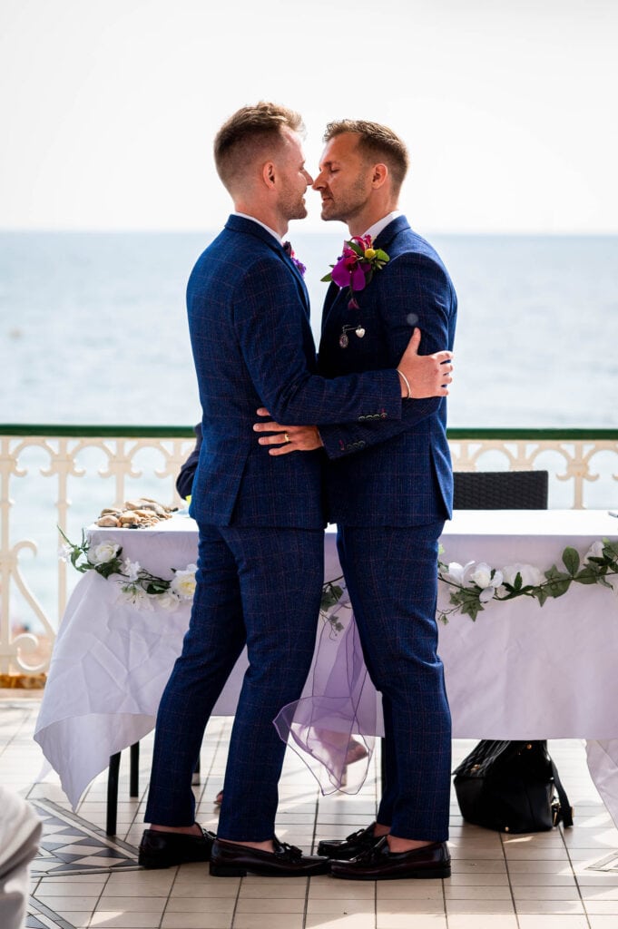 First kiss for grooms at their Brighton Bandstand wedding