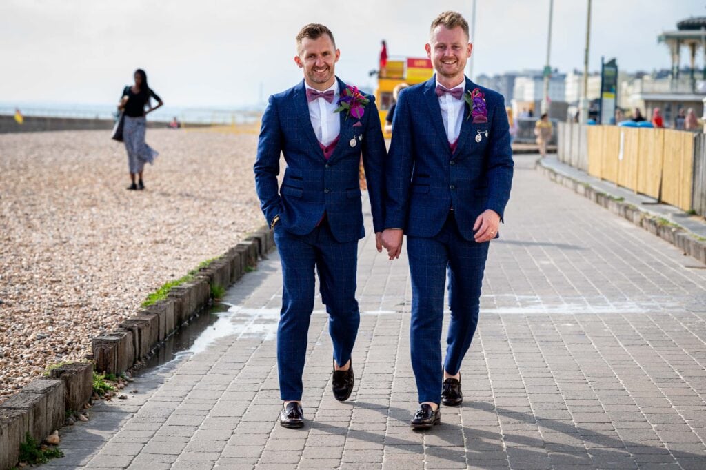 Newly wed grooms walking down Brighton Beachfront holding hands 