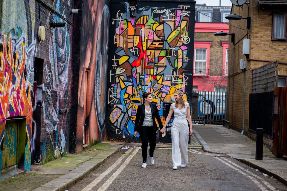 two brides walking past colourful Camden street art